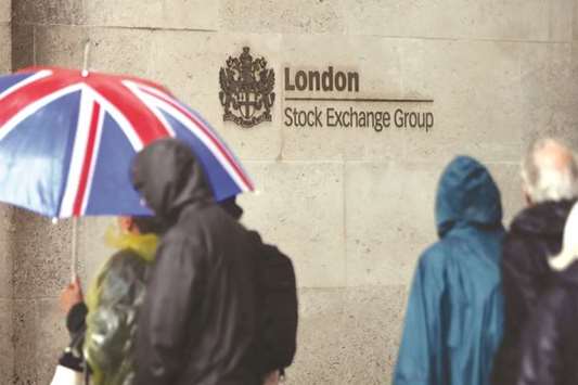Pedestrians walk past the London Stock Exchange. The FTSE 100 lost 0.5% to 6,888.69 points yesterday.