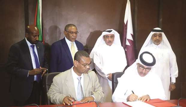 HE Jassim Seif Ahmed al-Sulaiti and Makawi Mohamed Awad witness the signing of the minutes of the meeting.