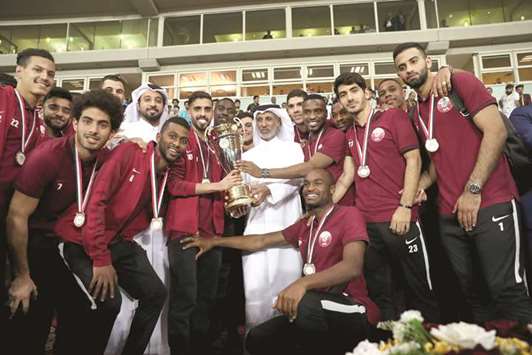Qatar captain Hassan al-Haydous and QFA President Sheikh Hamad bin Khalifa bin Ahmed al-Thani hold the International Friendship Championship Trophy as they pose with the team in Basra yesterday. At bottom, Bassem al-Rawi receives his Player of the Tournament award.