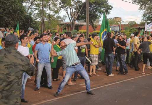 An opponent of former president Luiz Inacio Lula da Silva throws stones during a demonstration in front of the place where Lula held a meeting with supporters, in Foz do Iguacu, Parana state, Brazil. Lula arrived in Foz do Iguacu for a political gathering as part of his caravan across southern Brazil to rally his supporters.