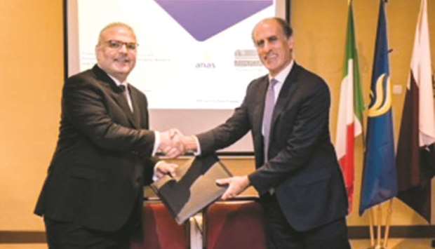 Saad bin Ahmed al-Muhannadi and ANAS representative shake hands after signing an MoU.