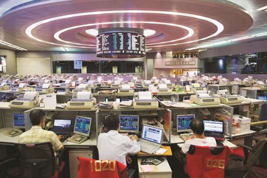 Traders work at the Hong Kong Stock Exchange (file). The Hang Seng closed down 2.5% to 30,022.53 points yesterday.