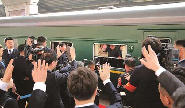 North Korean leader Kim Jong-un waving from his train as it prepares to depart from Beijing railway station.