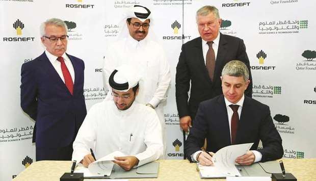 QFu2019s al-Kuwari and Rosneftu2019s Sechin sign an agreement as HE Dr Mohamed bin Saleh al-Sada and other dignitaries look on at QSTP yesterday.