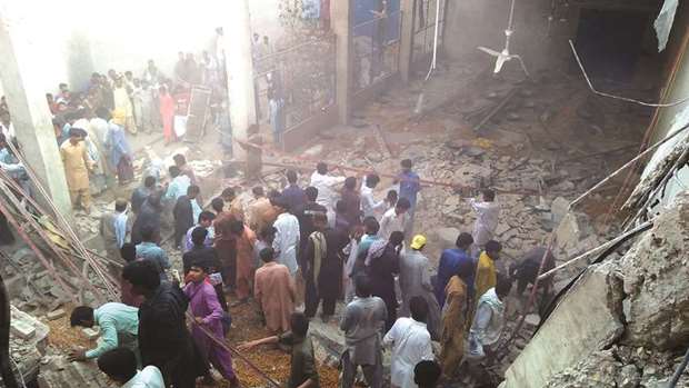 Residents and volunteers search for victims in the debris of a collapsed warehouse in Rohri district of Sindh province.