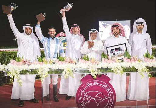 Qatar Racing and Equestrian Club (QREC) deputy chief steward Abdulla Rashid al-Kubaisi (third from right) with the winners of the Fuweiret Cup after MJ Lattam won the 1200m race at the QREC on Wednesday. PICTURES: Juhaim