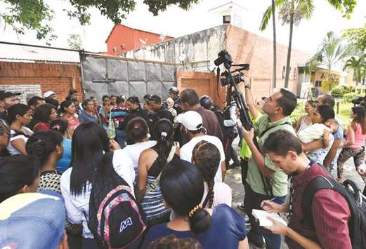Police officers give information to relatives of inmates and members of the media on the riot and fire that occurred at a police holding cell building in Valencia, northern Carabobo state, Venezuela.