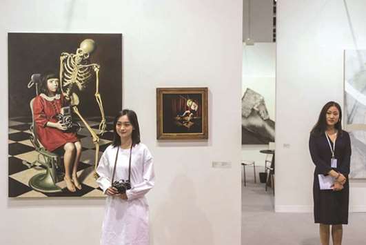 A woman stands in front of Japanese artist Masaru Shichinoheu2019s Recording Girl II and Midnight Grasshopper at Art Basel in Hong Kong yesterday.