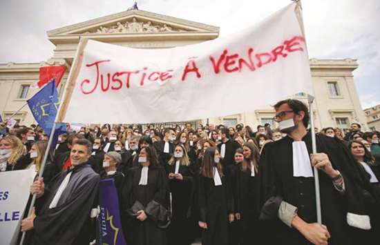 Lawyers attend a demonstration in front of Marseilleu2019s courthouse as part of a national profession-wide strike yesterday against planned justice reform law. The banner reads u2018Justice for saleu2019.