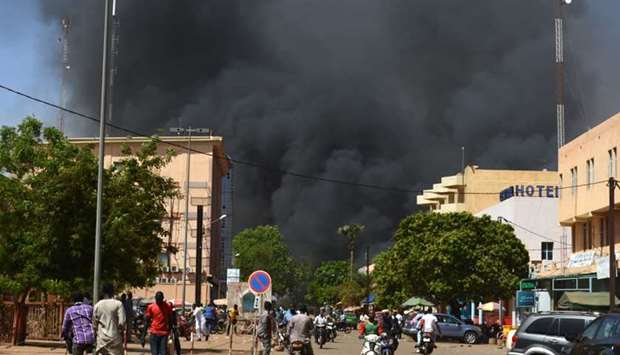 People watch as black smoke rises as the capital of Burkina Faso came under multiple attacks yesterday, targeting the French embassy, the French cultural centre and the country's military headquarters