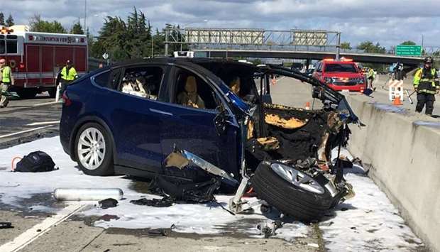 Rescue workers attend the scene where a Tesla electric SUV crashed into a barrier on US Highway 101 
