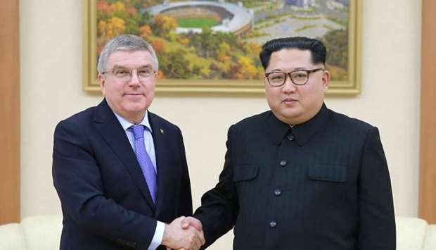 North Korean leader Kim Jong-Un (R) shaking hands with President of the International Olympic Committee Thomas Bach