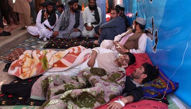 Afghan protesters lie as they receive Intravenous therapy (IV) drips during an hunger strike protest inside a tent in Lashkar Gah