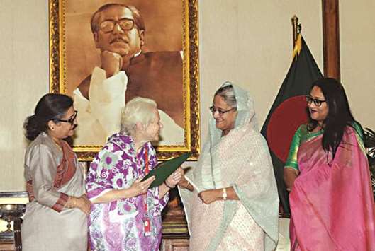Prime Minister Sheikh Hasina hands over the citizenship certificate to 87-year-old Lucy Helen at a function at her official residence Ganobhaban yesterday.