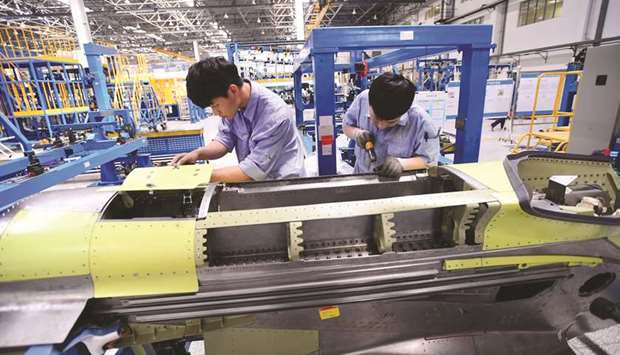 Workers assemble part of the engine for Chinau2019s self developed C919 passenger aircraft at a factory of Shenyang Aircraft Corporation in Liaoning province. Chinau2019s official Purchasing Managersu2019 Index released yesterday rose to 51.5 in March, from 50.3 in February, and was well above the 50-point mark that separates growth from contraction on a monthly basis.