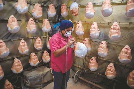 An employee gives the finishing touches to a latex mask of Mexican presidential candidate Andres Manuel Lopez Obrador, of the MORENA party, at Rev, a factory in Cuernavaca, Morelos State, Mexico. Mexico will hold general elections on July 1.