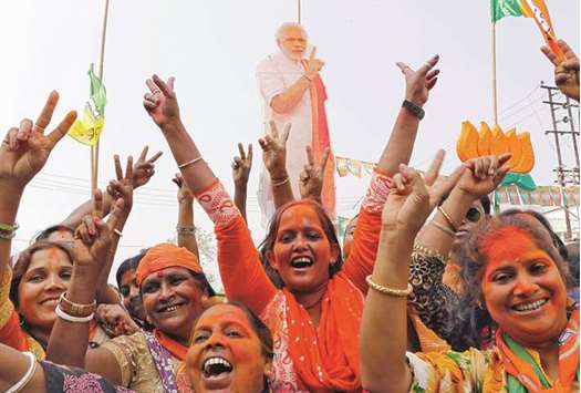 Supporters of the Bharatiya Janata Party celebrate in front of a cut-out of Prime Minister Narendra Modi after learning of the initial poll results of Tripura assembly elections, in Agartala, yesterday.