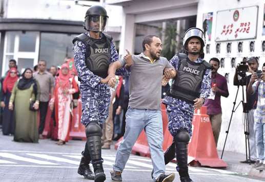 Maldivian police arrest a man at a protest appealing for the release of opposition leaders held in jail in the Maldives capital Male yesterday.