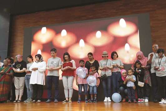 Family members hold candles during the fourth annual remembrance event for the missing Malaysia Airlines flight MH370, in Kuala Lumpur, yesterday.