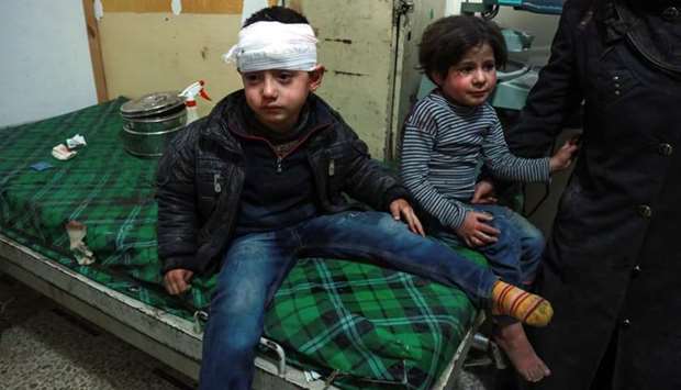 A bandaged Syrian child sits on a bed next to another child after receiving medical attention at a makeshift hospital in the rebel-held town of Douma, in the besieged Eastern Ghouta region on the outskirts of the capital Damascus, following reported regime bombardment yesterday.