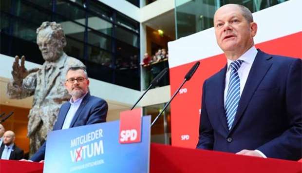 Olaf Scholz (right), interim leader of Germany's Social Democrats (SPD) party, speaks during a press conference at the party headquarters in Berlin on Sunday.