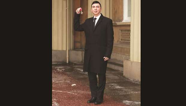 Musician Marc Almond poses with his medal after being appointed Officer of the Order of the British Empire (OBE) following an investiture ceremony at Buckingham Palace in London.
