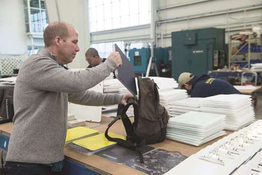George Tunis, CEO of Hardwire, demonstrates the use of his bulletproof backpack inserts at his factory in Pocomoke City, Maryland.