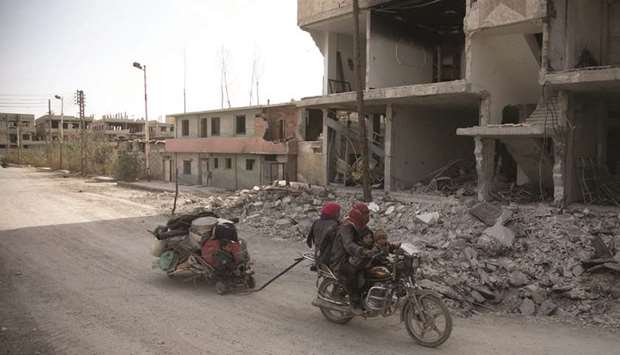 Syrians flee their homes with their belongings in the town of Beit Sawa in Syriau2019s besieged eastern Ghouta region yesterday, following reported air strikes.