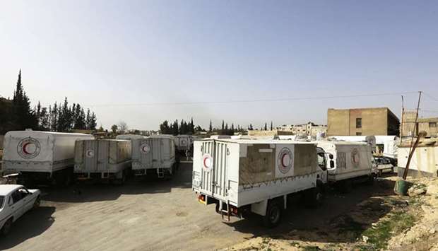Syrian Arab Red Crescent vehicles carrying aid wait at the al-Wafideen checkpoint on the outskirts of Damascus neighbouring the rebel-held Eastern Ghouta region before delivering aid to the rebel-held enclave