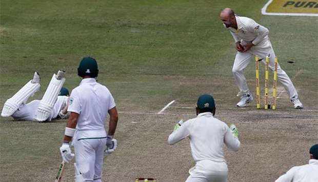 Nathan Lyon (top) breaks the stumps to run out AB de Villiers during the fourth day of the first Test between South Africa and Australia at the Kingsmead Stadium in Durban on Sunday.