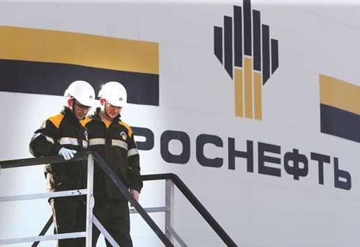 Workers stand next to a logo of Russiau2019s Rosneft oil company at the central processing facility of the Rosneft-owned Priobskoye oilfield outside the West Siberian city of Nefteyugansk (file). The Russian oil major took over ownership of the Kurdistan regionu2019s export oil and gas pipelines last year and agreed to provide it with over $2bn in loans, but the deal is not recognised by Baghdad, which says independent Kurdish oil exports are illegal.