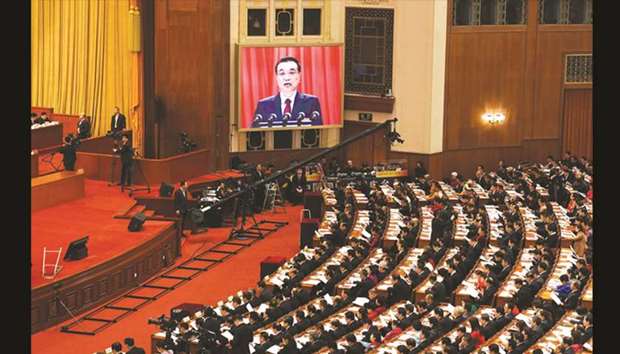 A live image of Chinese Premier Li Keqiang is seen on a screen as he delivers his work report during the opening session of the National Peopleu2019s Congress in the Great Hall of the People in Beijing yesterday.