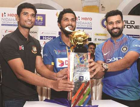 Sri Lanka captain Dinesh Chandimal (centre), India captain Rohit Sharma (right) and Bangladesh captain Mahmudullah Riyad pose with the Nidahas tri-nation Twenty20 series trophy during a press conference in Colombo yesterday. (AFP)