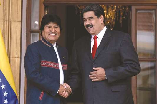Venezuelan President Nicolas Maduro shakes hands with his Bolivian counterpart Evo Morales during the Bolivarian Alliance for the Peoples of Our America (ALBA) summit at the Miraflores presidential palace in Caracas yesterday.