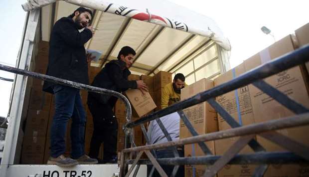 Workers unload parcels of humanitarian aid at the besieged town of Douma, Eastern Ghouta, Damascus, Syria