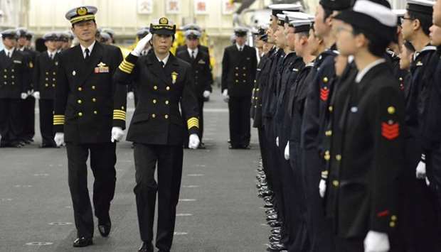 Newly-appointed Commander of First Escort Division of Japan Maritime Self-Defense Force (JMSDF) Ryoko Azuma (2nd L), who is the first female commander of a navy destroyer squadron in Japan, salutes to soldiers on JMSDF's helicopter carrier Izumo at a port in Yokohama, south of Tokyo.
