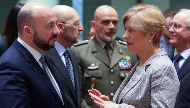 Luxembourg's Defence Minister Etienne Schneider talks with his Italian counterpart Roberta Pinotti during a European Union foreign and defence ministers meeting in Brussels