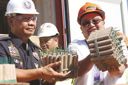 Customs personnel hold fireworks misdeclared as brackets at the port of Manila.
