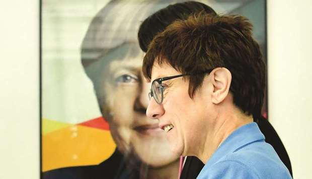    German secretary-general of the Christian Democratic Union (CDU) Annegret Kramp-Karrenbauer walks past a poster featuring German Chancellor Angela Merkel after addressing a press conference following a leadership meeting at the partyu2019s headquarters in Berlin on Monday. The Social Democrats party (SPD) agreed the day before to join a new coalition with Chancellor Angela Merkelu2019s conservatives CDU, heralding an end to the political stalemate that has plagued Europeu2019s biggest economy since Septemberu2019s inconclusive elections.
