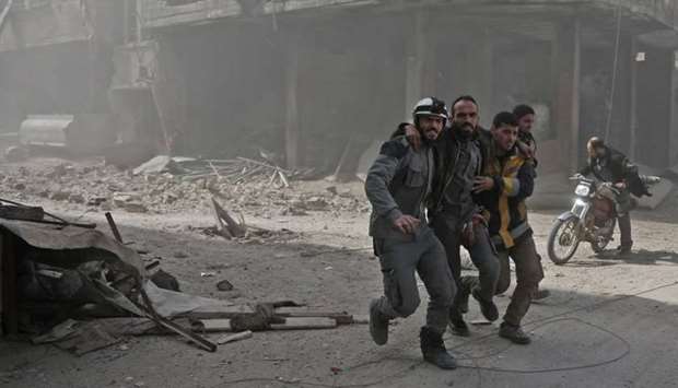 Volunteers from the Syrian civil defence help a man in Hamouria during Syrian government shelling on rebel-held areas in the Eastern Ghouta region on the outskirts of the capital Damascus.