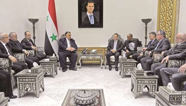 This handout picture released by the official Syrian Arab News Agency (SANA) shows Syrian Parliament Speaker Hammoudeh Sabbagh (centre left) with a German parliamentary delegation of seven from Germanyu2019s Alternative for Germany (AfD) far-right party, led by Christian Blex (centre right).