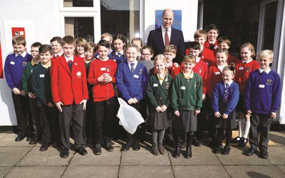 Prince William, Duke of Cambridge, poses with local school children as they take part in an engineering experiment during a visit to RAF Coningsby in Lincolnshire.