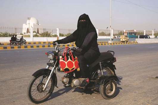 Humaira Jabeen, 32, mother of three and a family welfare worker, rides a motorbike on her way home on the eve of International Womenu2019s Day in Karachi, yesterday.