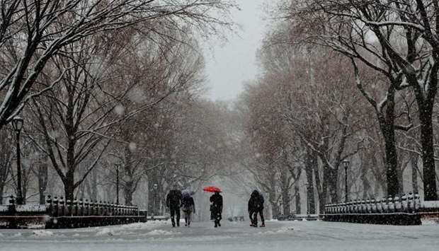 Pedestrians walk through Central Park during a snow storm in New York