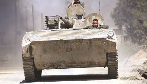Syrian government soldiers ride in an infantry-fighting vehicle (IFV) advancing in the town of Al-Mohamadiyeh, east of the capital Damascus, yesterday.