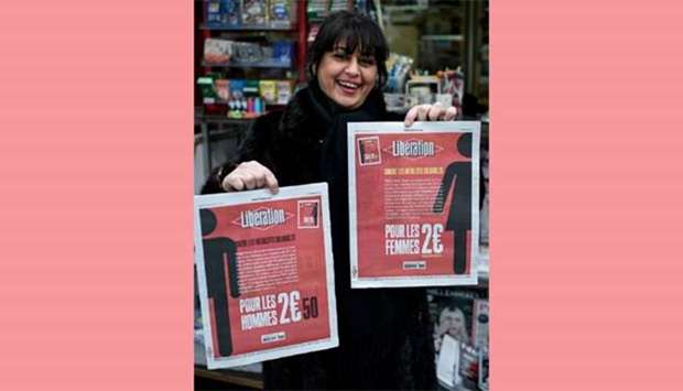 A woman holds two different front pages of the French newspaper Liberation in Paris on Thursday.