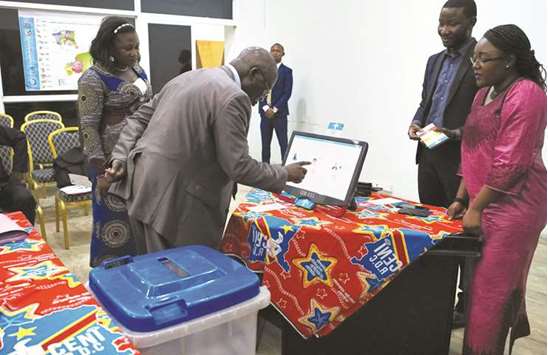 A man practices using an electronic voting machine during a demonstration inside Congou2019s electoral commission (CENI) head offices in Gombe Municipality of Kinshasa, Democratic Republic of Congo.