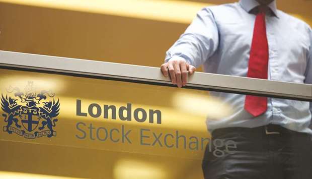 An employee leans on a glass wall above the main atrium of the London Stock Exchange Group headquarters. The FTSE 100 closed 0.3% up at 7,224.51 points yesterday.