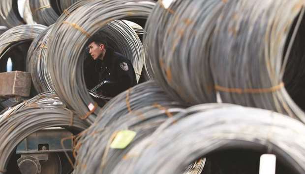 A security personnel checks steel products at a steel market in Shenyang in Chinau2019s northeastern Liaoning province. China yesterday denounced US tariffs on aluminium and steel imports, saying that they would profoundly harm the international trade environment.