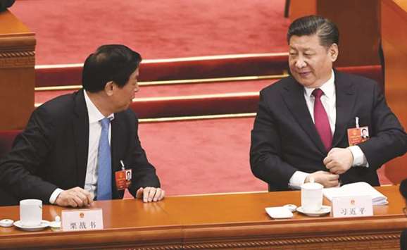 Politburo Standing Committee member Li Zhanshu (left) chats with President Xi Jinping during the second plenary session of the National Peopleu2019s Congress in Beijingu2019s Great Hall of the People yesterday.